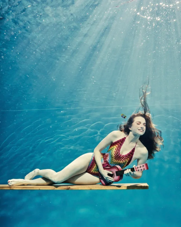 une jeune fille joue de la guitare sous l'eau