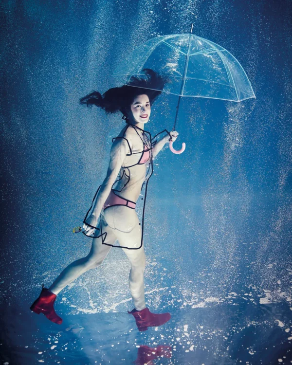 Une jeune fille marche sous la pluie avec un parapluie